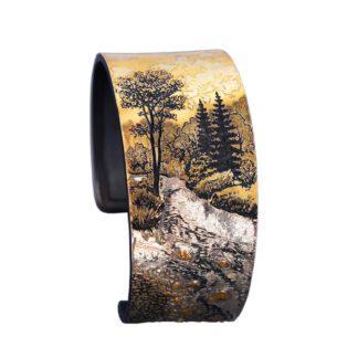 A bracelet with an image of trees and water.