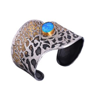 A leopard print bracelet with a blue stone on it.