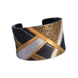 A black, gold and silver cuff bracelet with a leopard print design.
