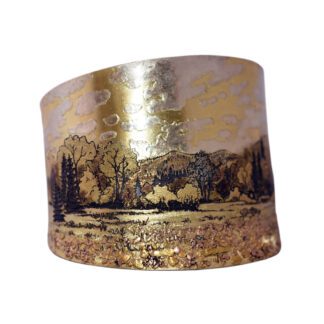 A gold and brown landscape painting on a cuff bracelet.