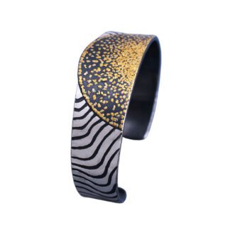 A close up of a bracelet with gold and black designs