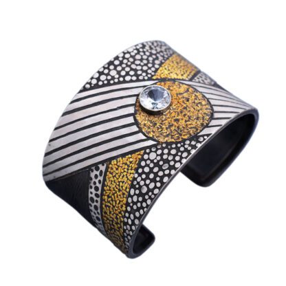 A silver and gold cuff bracelet with a diamond.