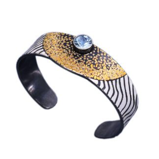 A black and white bracelet with gold and blue accents.