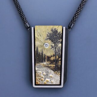 A necklace with a picture of trees and water.