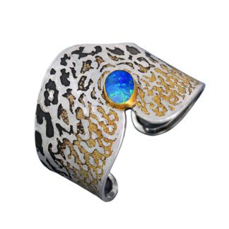 A cuff bracelet with gold and blue stone.