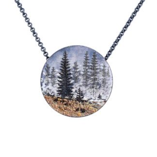 A necklace with trees and grass in the middle of it.