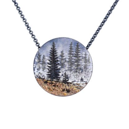A necklace with trees and grass in the middle of it.