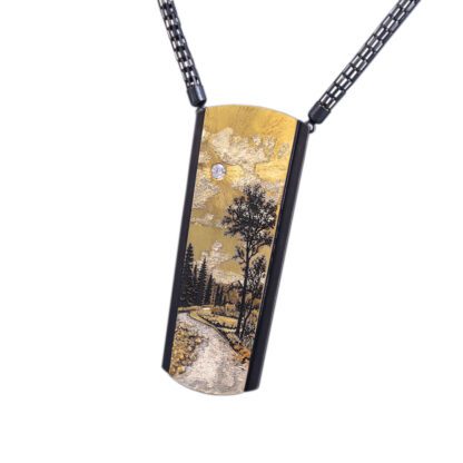 A painting of a tree and a road on a necklace.