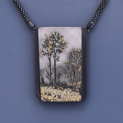 A painting of trees on a necklace.
