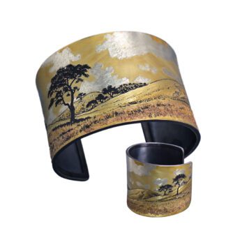 A painting of an african landscape on a cuff bracelet.