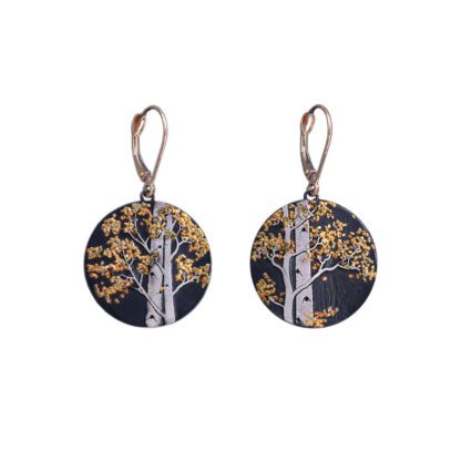 A pair of earrings with trees and gold leaves.