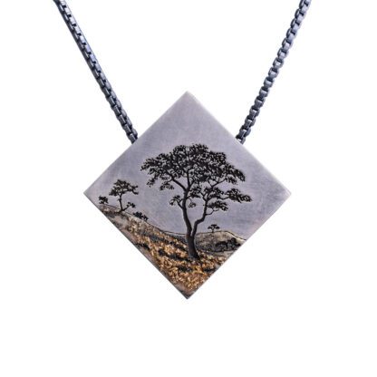 A necklace with an image of a tree on it.