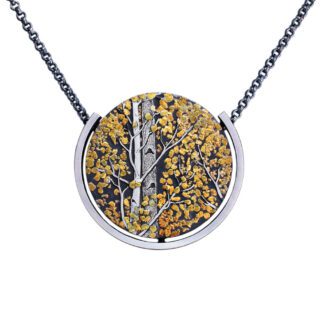 A silver necklace with a picture of trees.