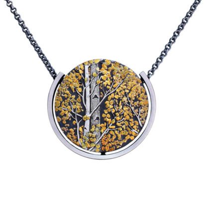 A silver necklace with a picture of trees.