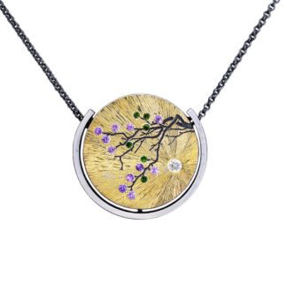 A necklace with a tree branch and purple flowers.