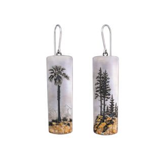A pair of earrings with palm trees and sand dunes.