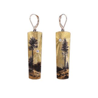 A pair of earrings with trees and mountains.