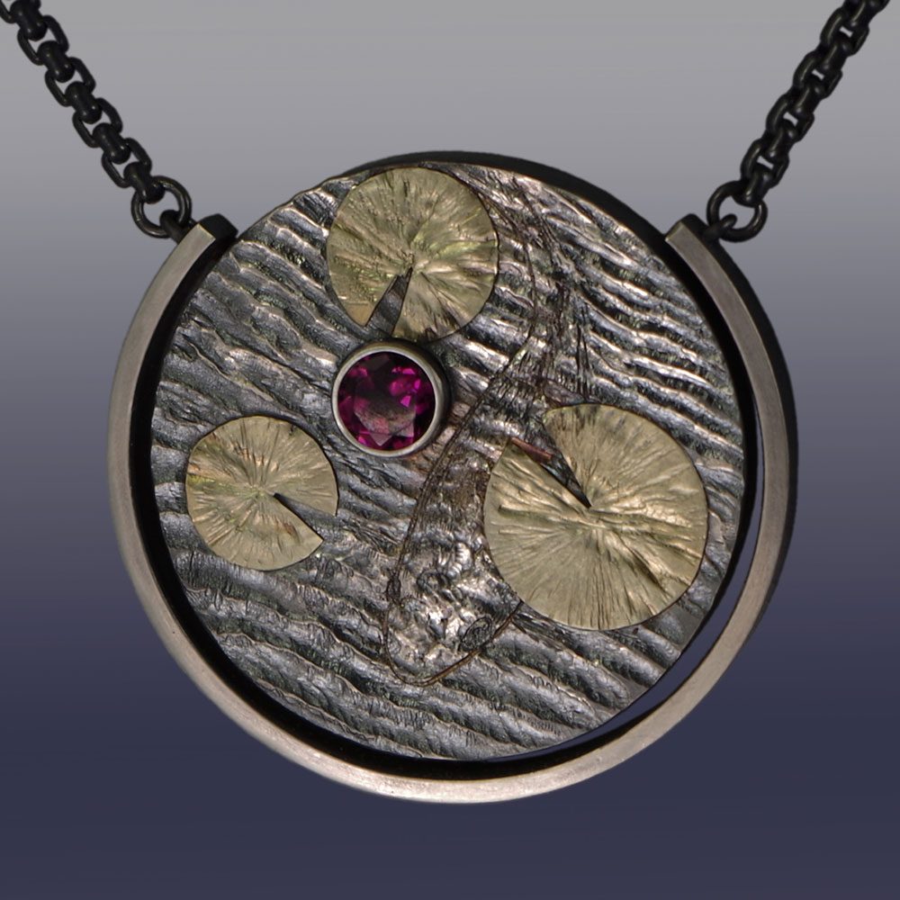 A necklace with a round pendant and a stone.