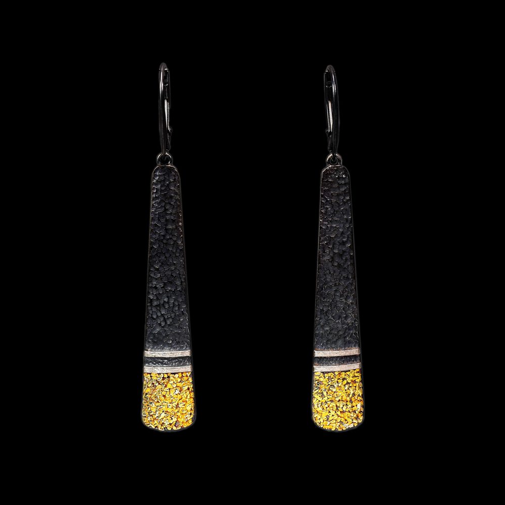 A pair of earrings with gold and black design.