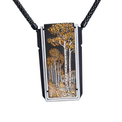 A rectangular pendant with trees painted on it.