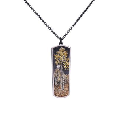 A necklace with a picture of trees on it.