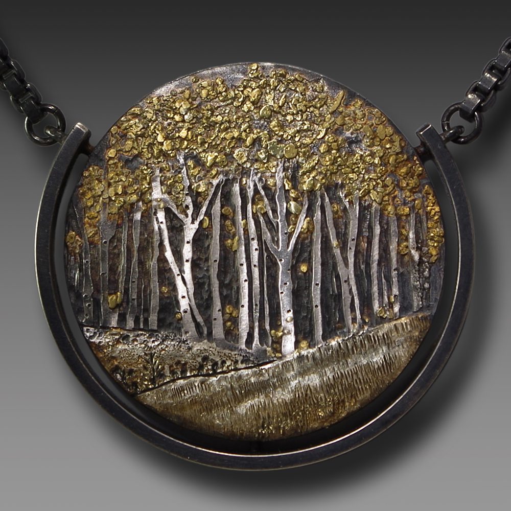 A necklace with trees and gold leaf on it.