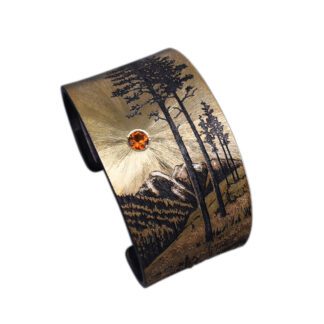 A cuff bracelet with an image of trees and a deer.