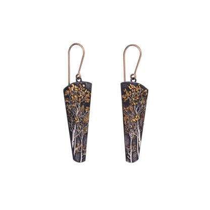 A pair of earrings with gold and black patina.