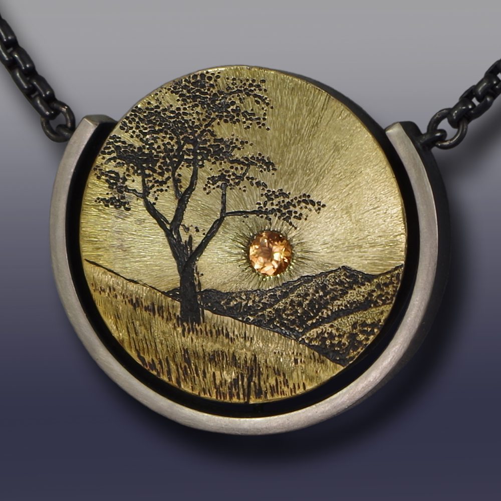 A necklace with a tree and sun in the middle of it.