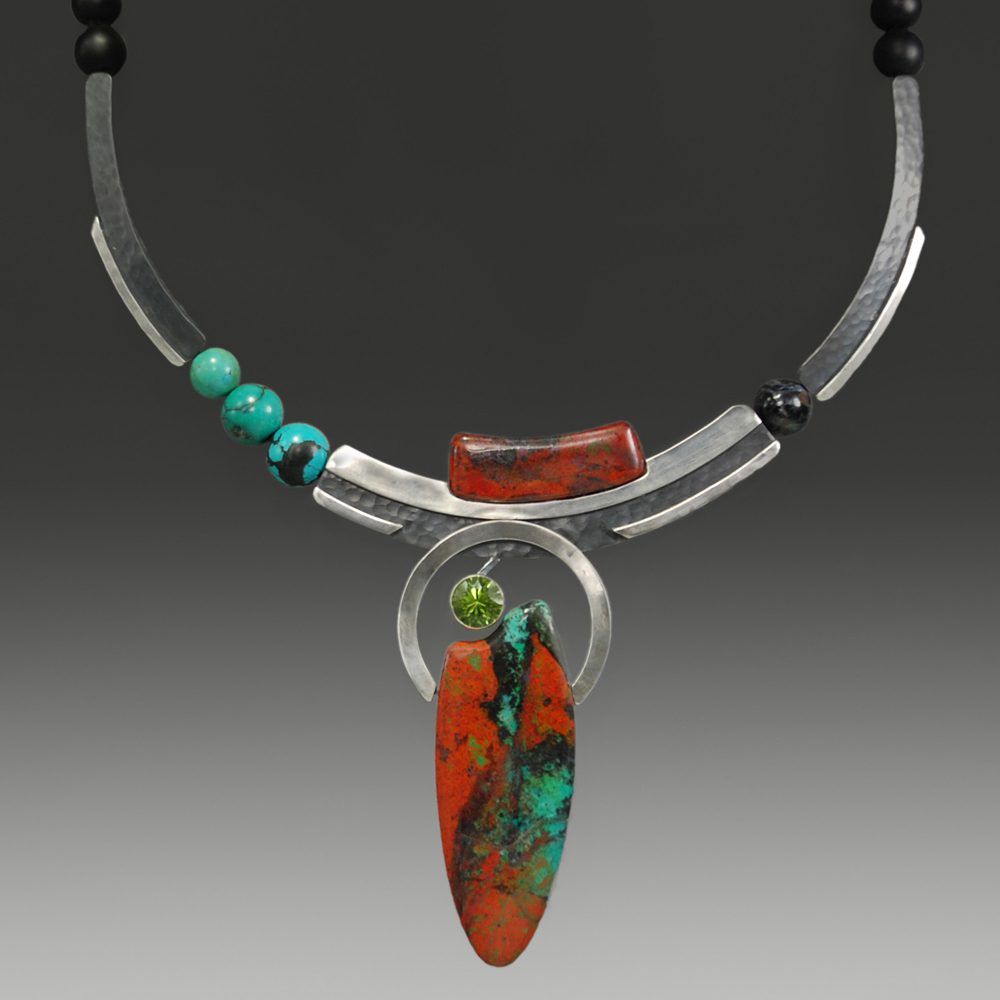 A necklace with an orange and green pendant.