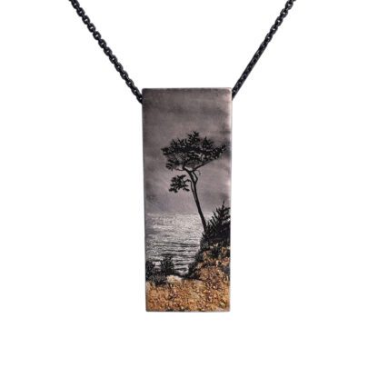 A necklace with a picture of a tree on it.