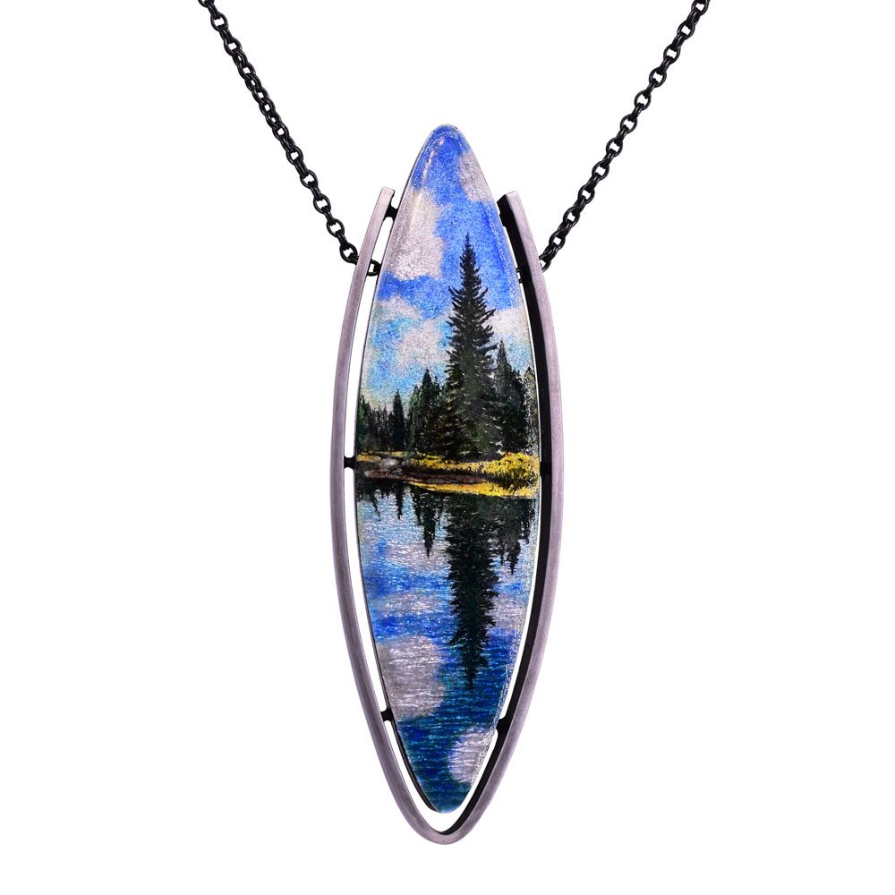 A necklace with a picture of trees and water.