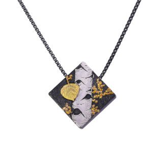 A necklace with a black and white square shaped piece of paper.