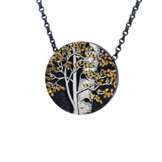 A necklace with a tree and a face on it.