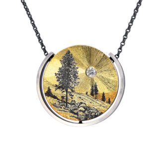 A necklace with a picture of trees and mountains.
