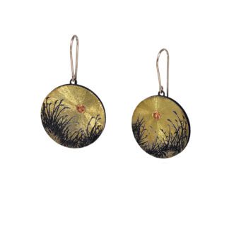 A pair of earrings with gold and black designs.