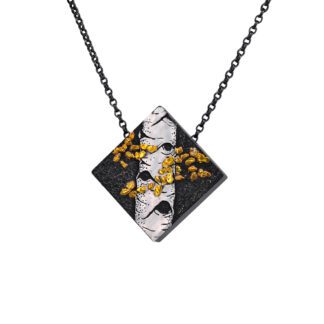 A black and white square necklace with gold leaf.