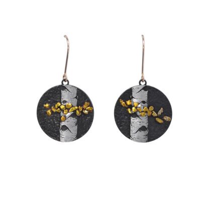 A pair of earrings with black and white stripes, gold leaves.