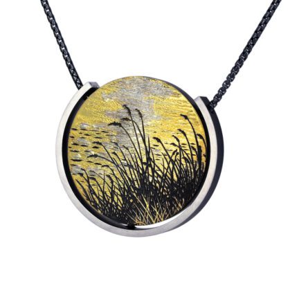 A necklace with a picture of grass in the middle.