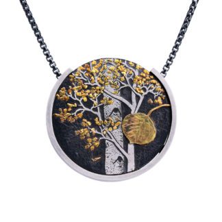 A necklace with a tree and sun on it.