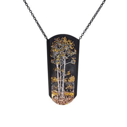 A necklace with a black and gold tree on it.