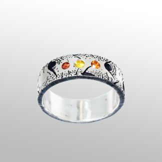 A silver ring with an orange and yellow design.