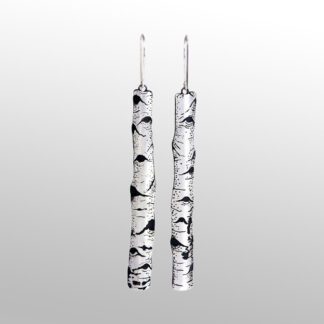 A pair of long silver earrings with black and white designs.
