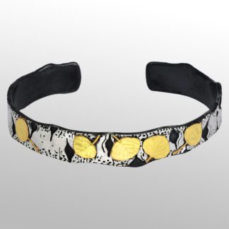 A black and white bracelet with gold leaves on it.