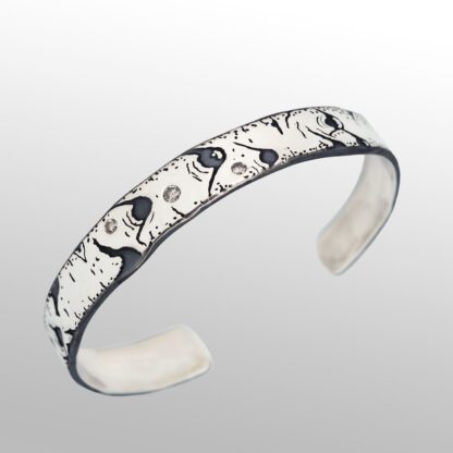 A white and black bracelet with swirls of paint.