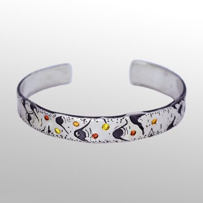A silver bracelet with a design of birds and flowers.