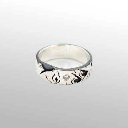 A silver ring with a face on it