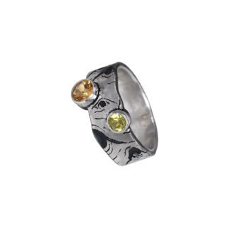 A silver ring with two yellow stones on it.