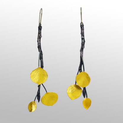 A pair of yellow earrings hanging from black string.