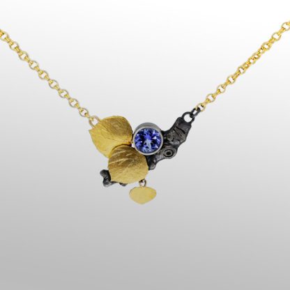 A gold necklace with a blue stone and black diamond.